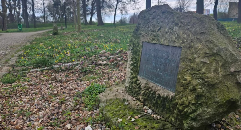 Zaniedbana ścieżka i kamienie z tabliczkami na ścieżce pamięci